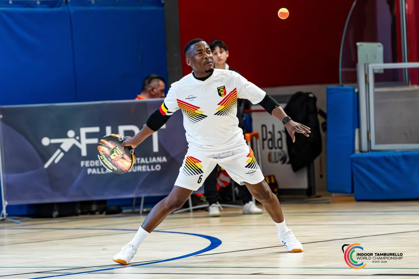 Narcisse Amoussou, capitaine de l’équipe nationale belge, en maillot blanc, prépare sa frappe au Championnat du Monde Indoor de Rome, en 2026