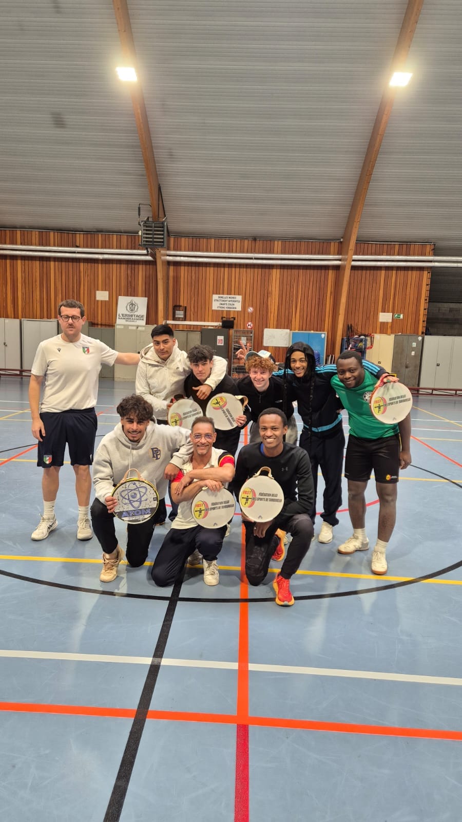 Groupe de joueurs réunis sur le terrain tracé d'une salle omnisports